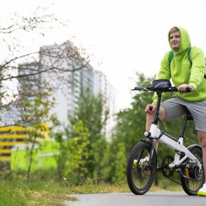 Sprzedaż rowerów elektrycznych bije rekordy Młody mężczyzna w bluzie z kapturem na rowerze elektrycznym